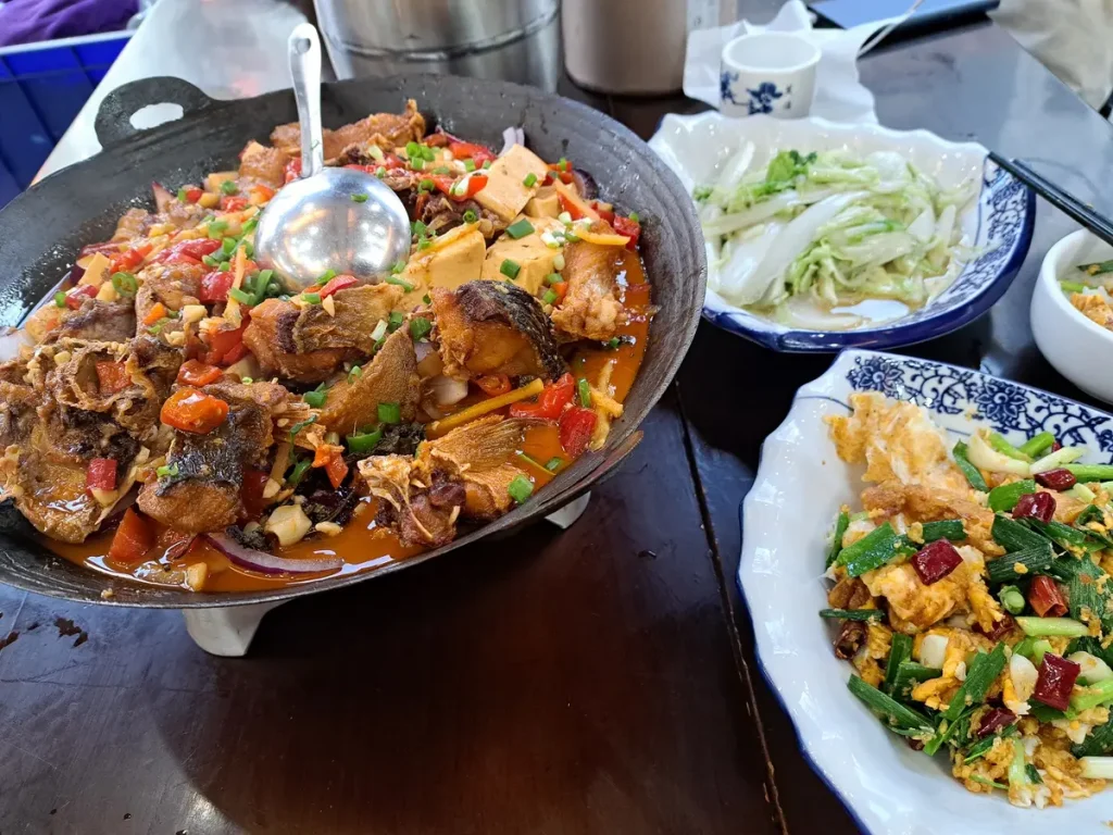 Mit meiner Schwägerin lässt es sich gut essen. Hier ein Fisch-Tofu-Gericht, Chinakohl und gebratene Enteneier