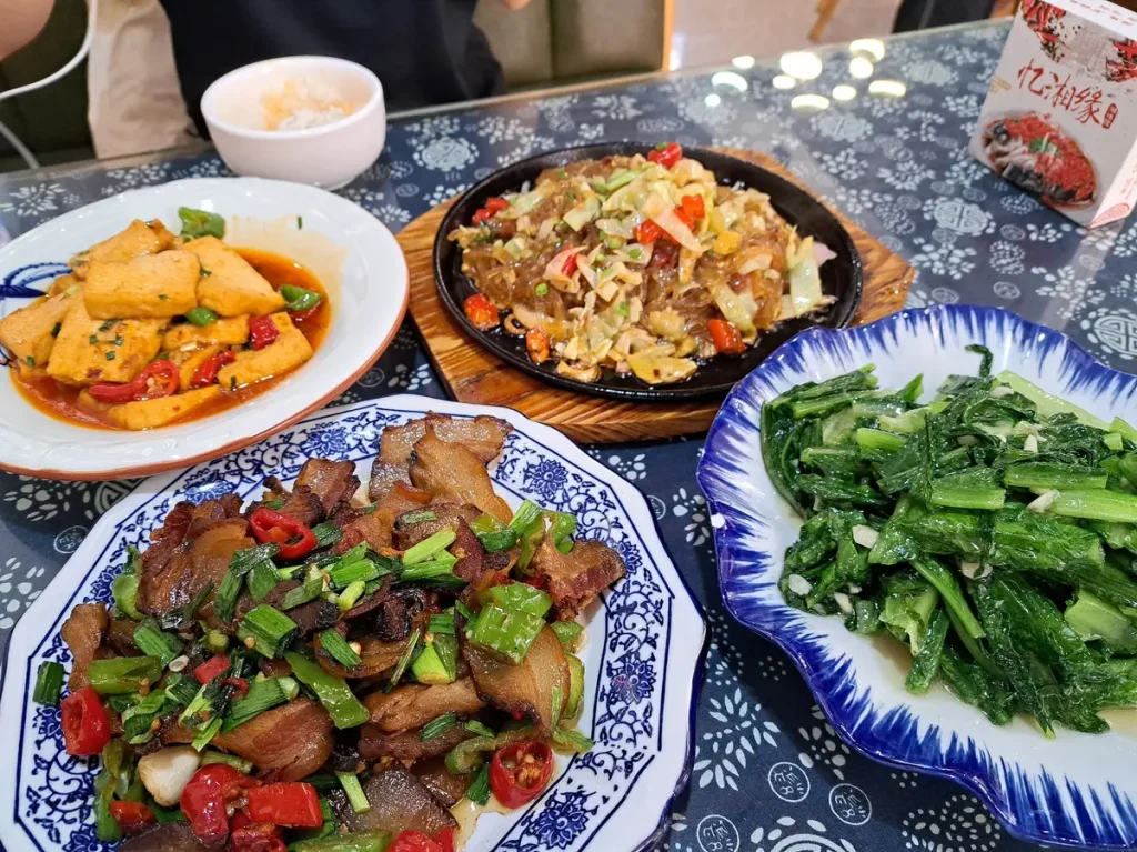 Auch diese Mahlzeit schmeckt prima. Es gibt Tofu, Glasnudeln, ein für diese Gegend typisches Speckgericht und grünes Gemüse.