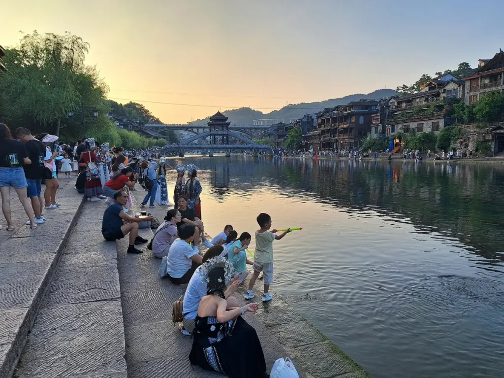 Die Kinder spielen am Fluss und die Frauen machen ein Fotoshooting vor dem schönen Hintergrund.