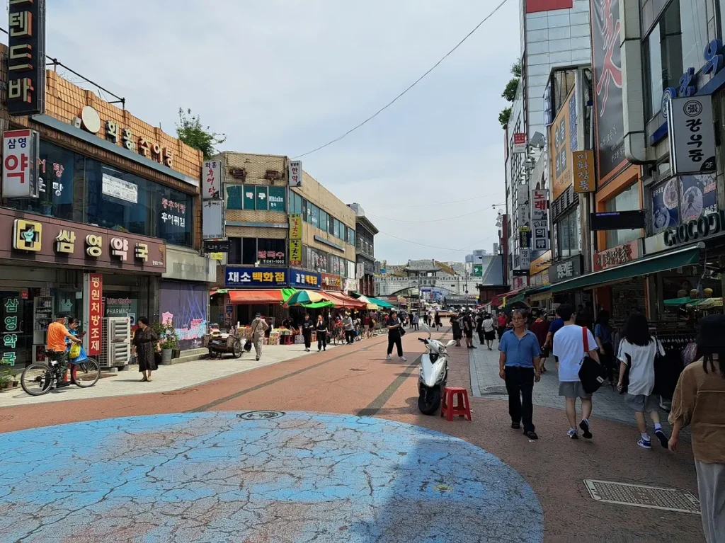 eine Marktstrasse in Suwon - im Hintergrund sieht man einen Teil der allgegenwärtigen Festungsmauer