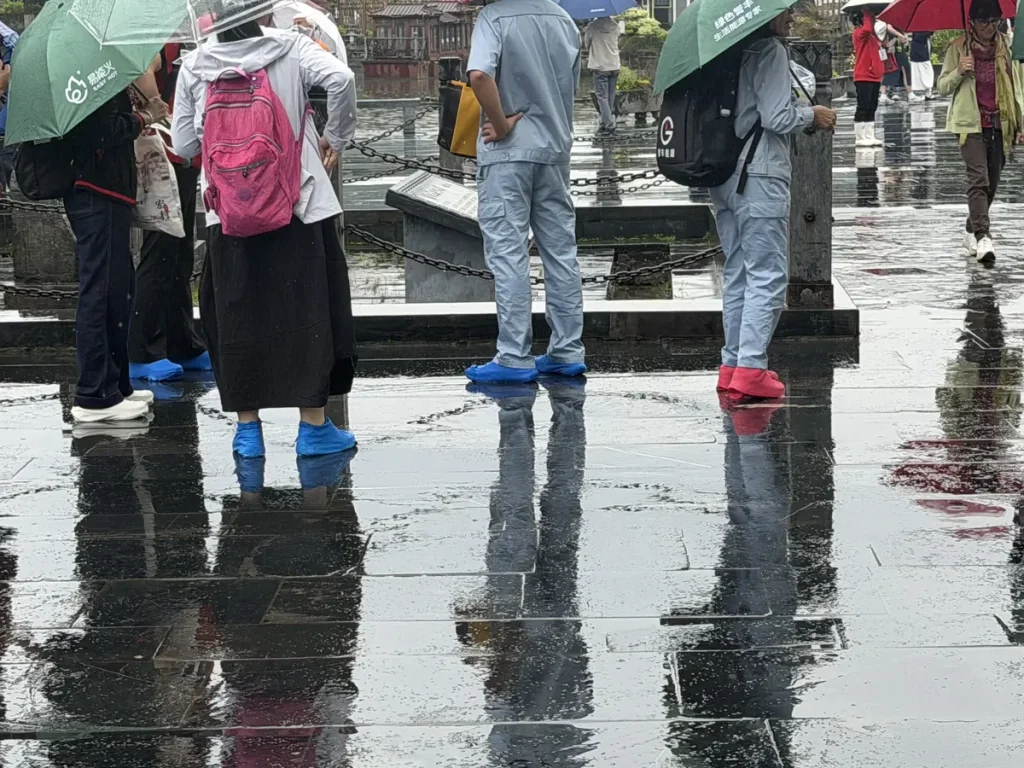 die Chinesen sind bestens auf das Regenwetter vorbereitet, mit Gummischutz über die Turnschuhe