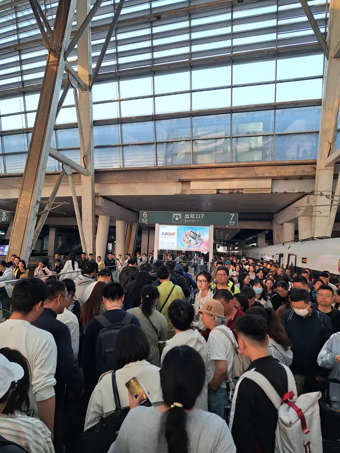 Ankunft im Bahnhof Beijing South. Alle drängeln sich Richtung Rolltreppen