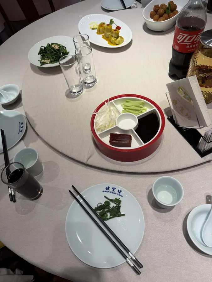 man wickelt sie dann in dünne Pfannkuchen, zusammen mit Hoisin-Sauce und dünn geschnittenen Gurken und Frühlingszwiebeln