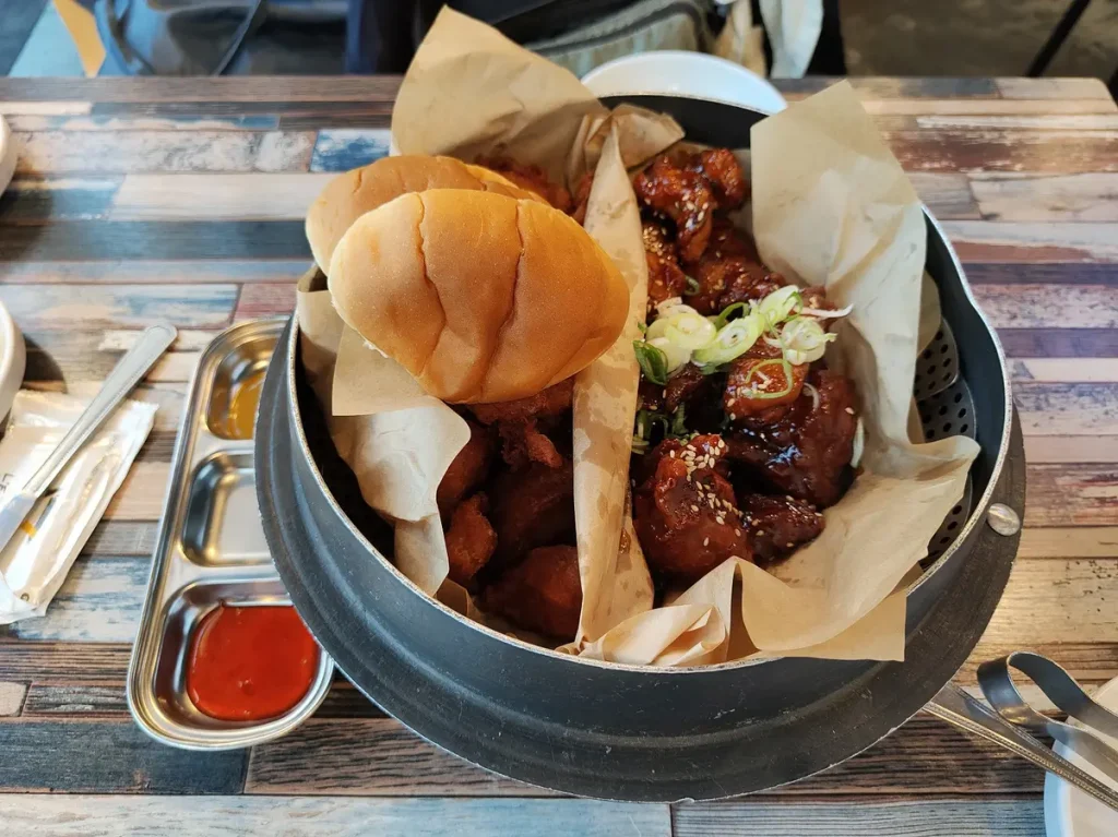 Korean Fried Chicken in 2 verschiedenen Sorten - lecker und sehr zu empfehlen. Dazu werden eingelegte Rettichwürfel gegessen, die etwas Säure mit ins Spiel bringen.