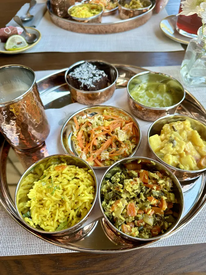 Mittagessen mit verschiedenen Curries, Reis und einem Melonen-Lassi und Brownie als Dessert
