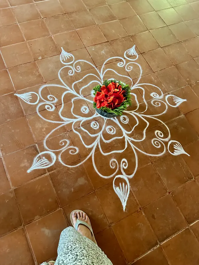 Rangoli - traditionelle indische Kunstform, bei der mit farbigem Pulver, Sand, Blütenblättern oder Reismehl dekorative Muster auf den Boden gestreut werden